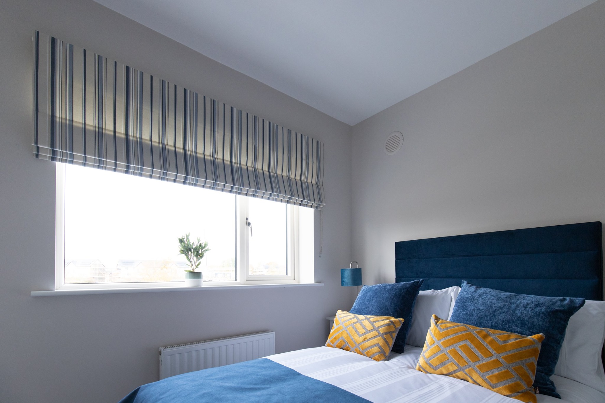 This bedroom features a roman blind in our ever-popular Audrey Stripe fabric.