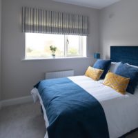 This bedroom this subtle roman blind adds a touch of character and colour to this beautiful bedroom.